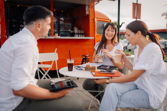 Friends enjoying coffee at outdoor food truck cafe