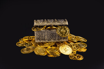 Open treasure chest with gold coins on black background © PhamHong