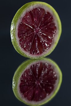 Closeup Of Vibrant Lime With Glossy Surface. Macro Image Displaying Ruby Flesh And Shiny Skin Of Lime