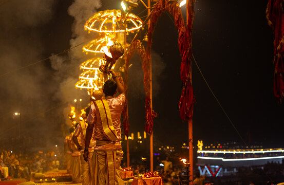 Ganga aarti, Portrait of young priest performing holy river ganges evening aarti at assi ghat in traditional dress with hindu rituals.
