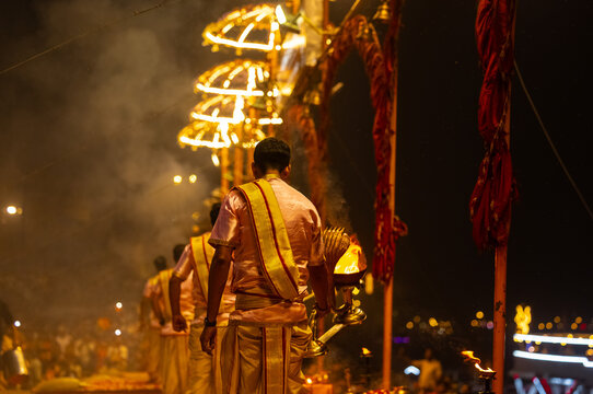 Ganga aarti, Portrait of young priest performing holy river ganges evening aarti at assi ghat in traditional dress with hindu rituals.