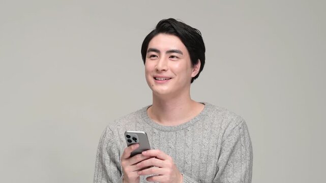 スマートフォンを持って微笑む30代の日本人男性