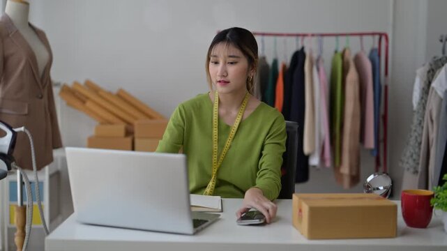 Asian fashion designer preparing a package in her office