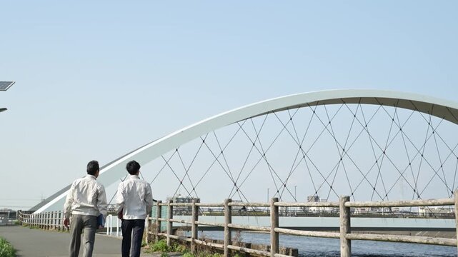 橋梁工事の現場で指差しをしながら歩く30代と50代の作業員