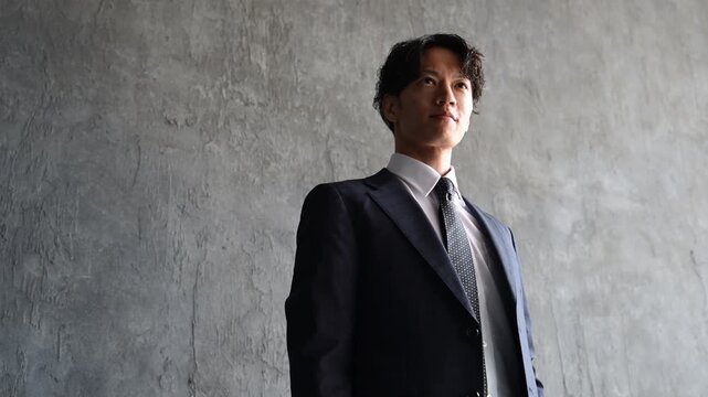 真面目な表情で立つ30代の日本人ビジネスマン