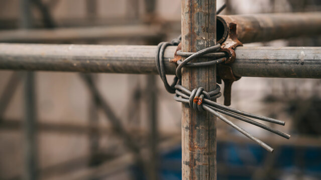 Industrial metal scaffolding poles secured together with twisted steel wire