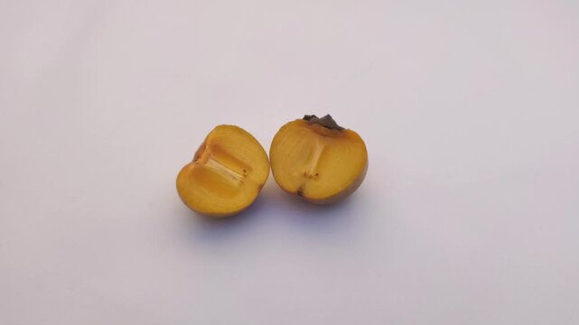 A fresh persimmon or Diospyros kaki on a white background