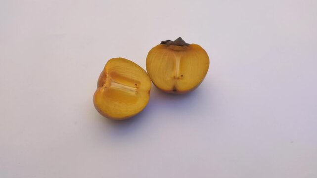 A fresh persimmon or Diospyros kaki on a white background