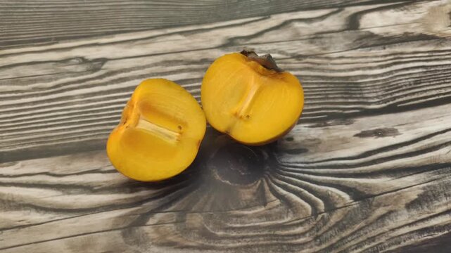 A fresh persimmon or Diospyros kaki on a wooden table