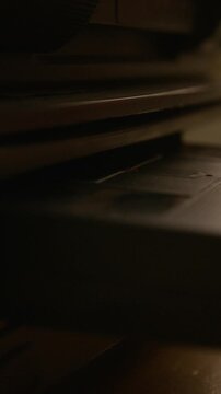 Vertical of hand of woman inserting VHS tape labeled Zombie Attack into retro VCR player for watching film. Clip is ideal for retro technology or horror movie themed marketing campaigns