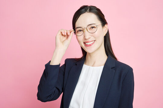 メガネに触れる笑顔のビジネスウーマン