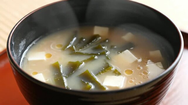 Close-Up Steaming Bowl Of Lacquered Miso Soup With Tofu And Seaweed Creating An Inviting Culinary Scene For Asian Dining