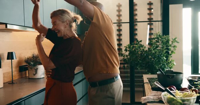 Happy, dancing and holding hands in kitchen for meal prep, fun cooking or vibe together. Hug, interracial couple or mature people in house with food and love for weekend romance, holiday or bonding