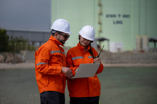 Engineers discussing project on laptop at lng terminal
