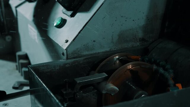 Close-up of industrial metalworking machine with rotating cutting disc