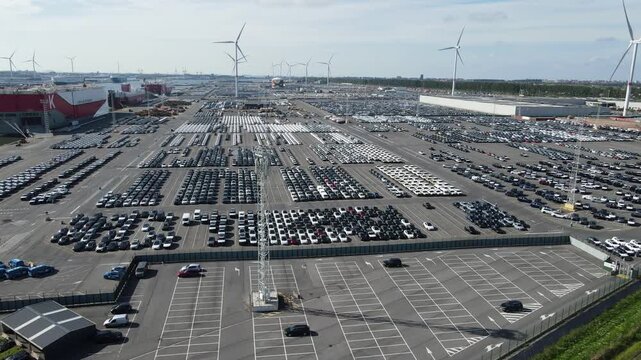 Fast drone circle approaches dense car rows with liners and floodlights behind.