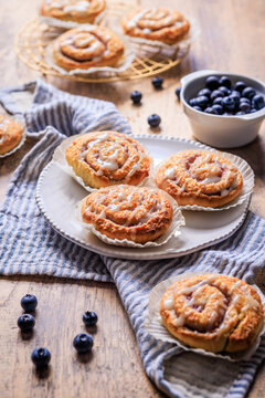 Delicious blueberry cinnamon rolls with sweet icing on a rustic wooden table