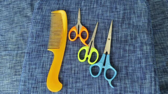 Closeup of hand taking male personal grooming equipment trimmer from table with comb and scissors. Mens manscaping or basic home hair care routine preparation concept.