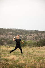 Boy throwing baseball outside in field © Cavan