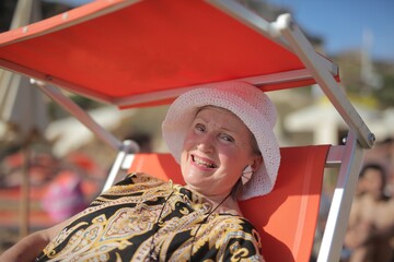Happy senior woman relaxing in a beach chair © Cavan