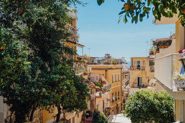 Naklejka premium Charming Italian street view with lush orange trees in Taormina