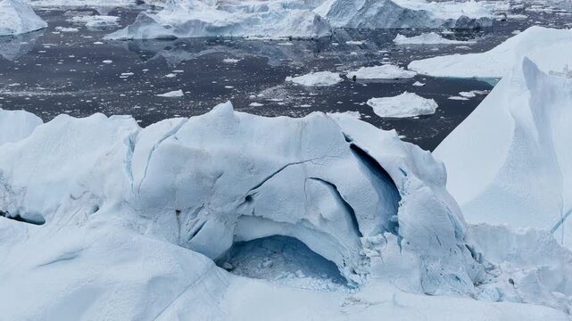 Massive iceberg with ice cave in arctic ocean
