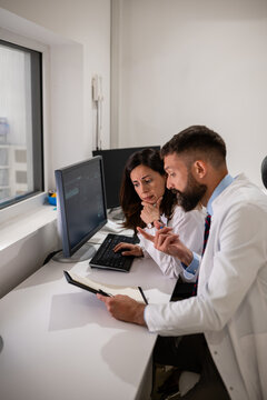 Medical professionals collaborating on computer research and data