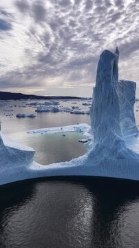Massive iceberg wall towers over an arctic ocean