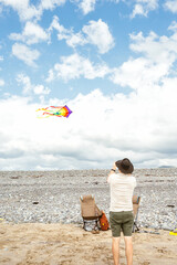 Man flying a colorful kite at the seaside © Cavan