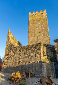 Folded chairs beside medieval castle tower in Peratallada Catalonia