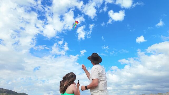 Father and daughter flying a colorful kite together