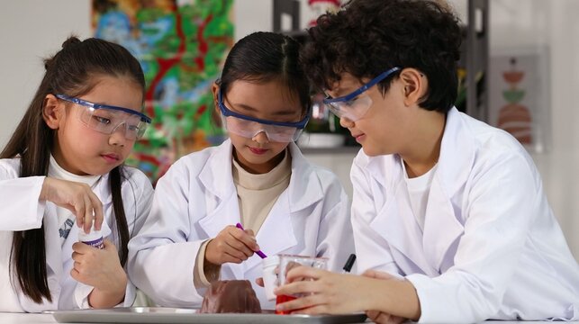 Asian Students in Lab Coats Conducting a Science Volcano Experiment