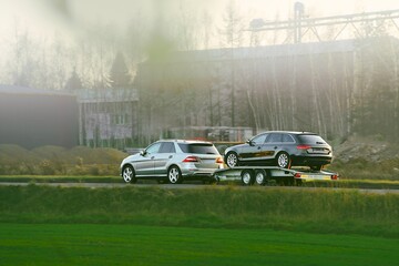 Fototapeta premium Tow truck hauling black car and white van