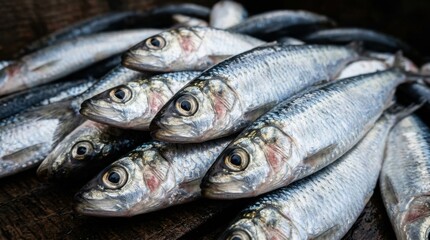 Obraz premium A close-up view of a pile of fresh, silver sardines, showcasing their detailed scales and eyes, perfect for culinary inspiration.