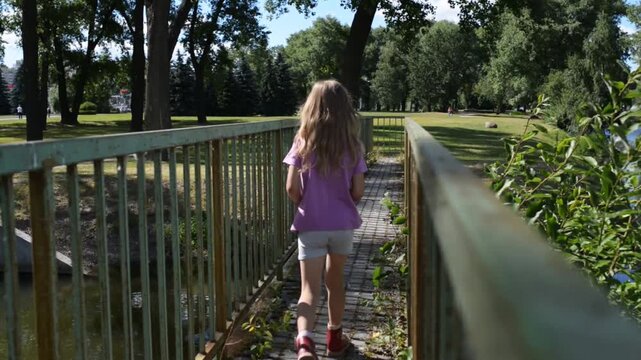 Little girl goes on metal bridge