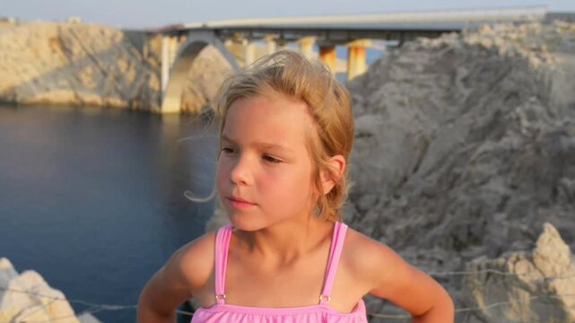 Little beautiful girl near bridge. Island of Pag