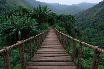 Obraz premium Narrow rope and plank bridge through misty green valley for hiking background wallpaper and outdoor adventure banner design