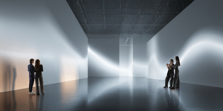 People stand in minimalist white immersive room with abstract light projections, soft haze, reflective floor, and spacious layout. Fits spatial design, tech demos, and digital experience campaigns.
