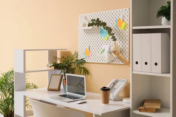 Interior of stylish office with workplace, pegboard and shelf unit © Pixel-Shot