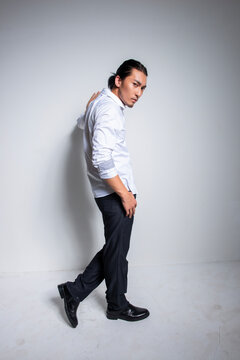 Asian man wearing shirt and trousers poses for photos