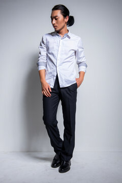 Asian man wearing shirt and trousers poses for photos