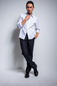 Asian man wearing shirt and trousers poses for photos