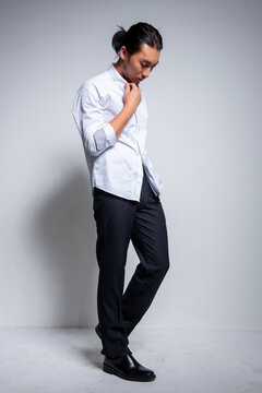 Asian man wearing shirt and trousers poses for photos