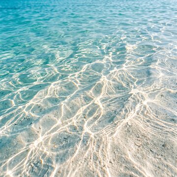 Clear turquoise ocean water with sun reflections on white sandy bottom close up view.