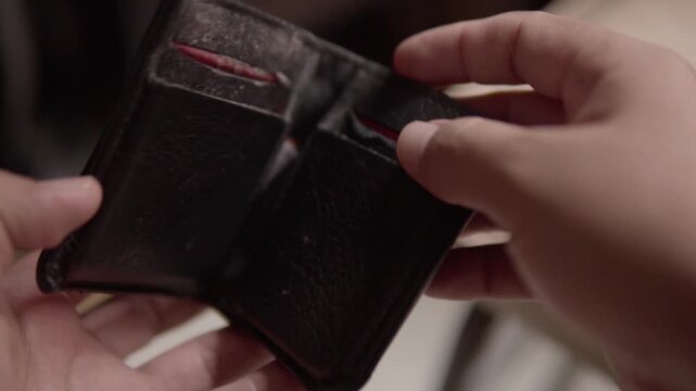 Close up of a person looking into an empty wallet, illustrating financial hardship, lack of cash, budgeting challenges and personal money concerns.