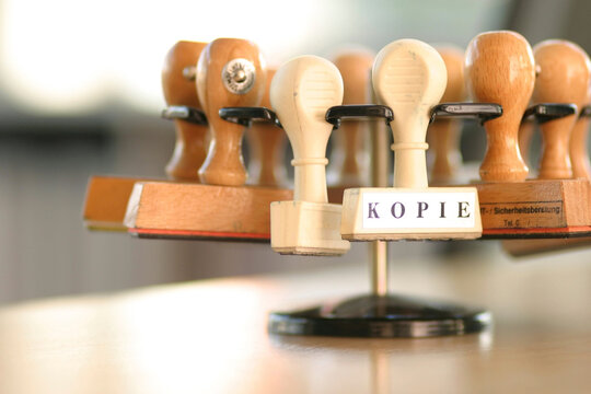 Wooden rubber stamp with the word Kopie on an office desk