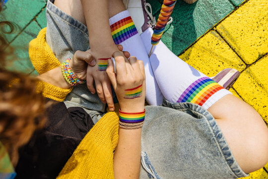 Painting rainbow flag on hand outdoors during pride parade