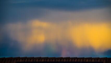 Naklejka premium Bizarre colorful sky sight over rooftop