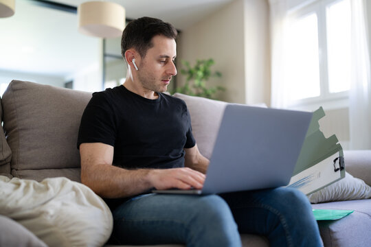 Freelancer telecommuting with laptop and documents at home