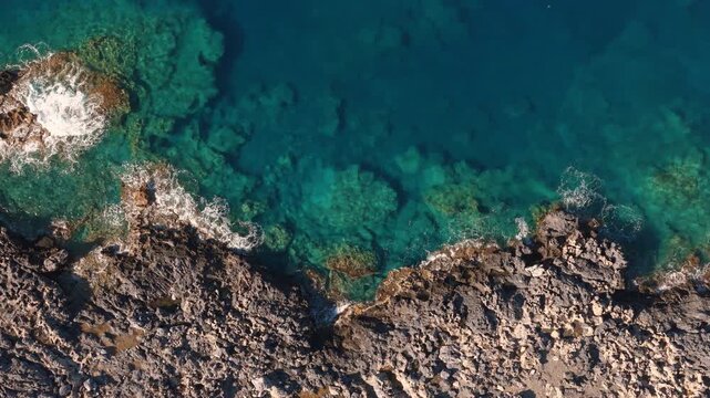 Drone video on the Crete island rocky coastline with clear blue water on a sunny day of summer
